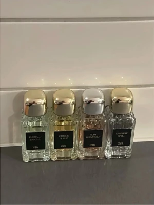 Zara parfymset med fyra dofter - Säljer ett parfymset från Zara med fyra olika dofter: Emerald Enigma, Citrine Flame, Ruby Bravement och Sapphire Spell. Flaskorna är små, fyrkantiga och har eleganta metallfärgade lock i guld och silver. Perfekt för dig som vill testa olika parfymer.