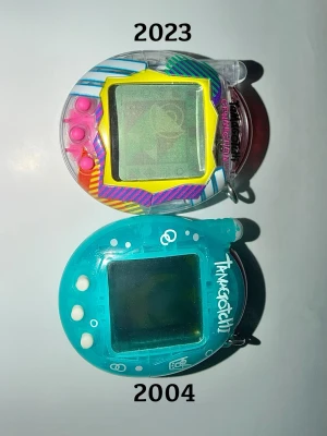 Två Tamagotchi Connection V3 - Den ursprungliga "Connection"-serien släpptes först 2004, och en 20-årsjubileumsversion återlanserades 2024. Den ena är från 2004 och den andra är 2023.  Den från 2004 har tecken på slitage, men är inget som påverkar funktionen.  Behöver nytt batteri CR2032 eftersom dessa batterier har tagit slut. Spela spel, samla pengar, byta presenter och skapa en familj! Spara upp mot 300kr för paketpriset. Använd min Bundle för ännu billigare!  Inga bud.  #Tamagotchi #TamagotchiConnection #Retroleksaker 