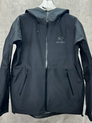 Arc'teryx Beta LT - Säljer en helt ny och oanvänd Arc'teryx Beta LT i den mest eftertraktade färgen Black. Jackan har alla original-tags kvar (NWT) och har aldrig blivit använd. Jag har köpt in ett litet parti från en utländsk butik som gått i konkurs, därav kan jag sälja den till ett riktigt vasst pris. Givetvis 100% äkta (skickar gärna fler bilder på lappar/sömmar om du vill kika). 