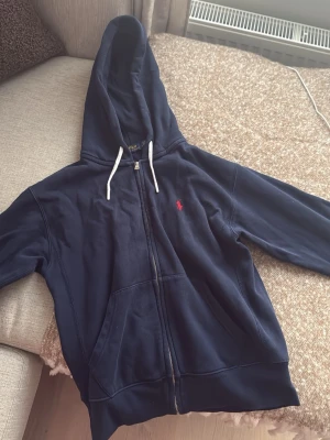 Marinblå hoodie från Polo Ralph Lauren - Snygg marinblå hoodie från Polo Ralph Lauren med  zip och logga på bröstet. Inte använd särskilt mycket.
