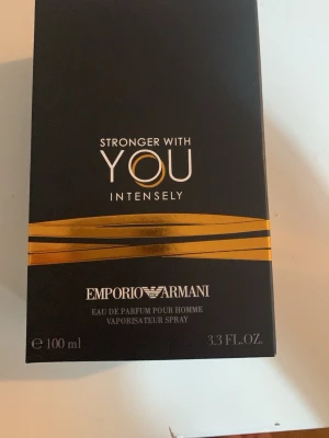 Emporio Armani Stronger With You Intensely 100ml - Emporio Armani Stronger With You Intensely Eau de Parfum Pour Homme i en elegant svart förpackning med guldiga detaljer. Flaskan rymmer 100 ml och doften är intensiv och maskulin, perfekt för dig som vill sticka ut med en modern och självsäker parfym.