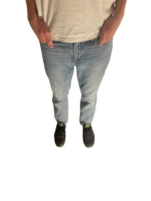 Ljusblå raka jeans Levi's - Klassiska ljusblå jeans från Levi's med rak passform och normal midja. Jeansen har fem fickor och stängs med dragkedja och knapp. Perfekta för en avslappnad och tidlös stil.