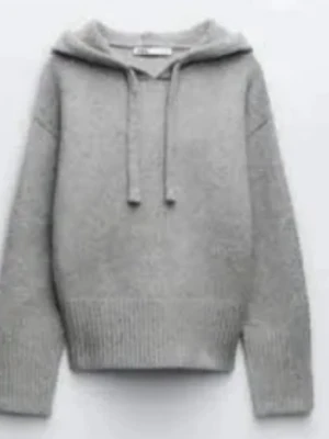 Grå stickad hoodie med huva - Mysig grå stickad hoodie från Zara med huva och dragsko. Tröjan har en avslappnad passform, ribbade muddar och bred fåll. Perfekt för en chill och stilren look.