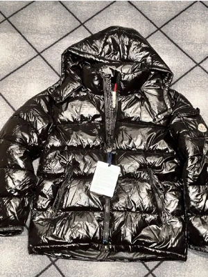 Svart glansig dunjacka från Moncler - Säljer en svart glansig dunjacka från Moncler med huva och dragkedja framtill. Jackan har två framfickor med dragkedja och Moncler-logga på ärmen. Perfekt för kalla vinterdagar och riktigt snygg streetstil.