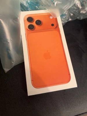 iPhone orange med trippelkamera - Helt ny aldrig använd. Snygg orange iPhone från Apple med stilren design och trippelkamera på baksidan. Telefonen har rundade hörn och är tillverkad i glas och aluminium. Perfekt för dig som vill sticka ut med en färgglad mobil och ta grymma bilder.