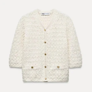 Vit stickad kofta från Zara - Säljer en krämvit stickad kofta från Zara med v-ringning och guldknappar framtill. Koftan har trekvartsärm och två små fickor framtill😇