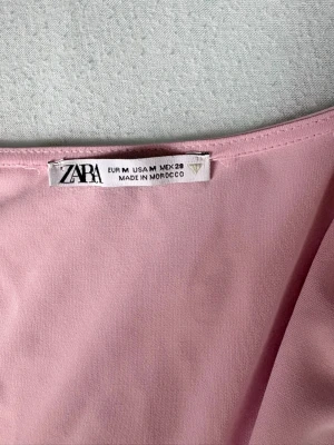 Ljusrosa topp från Zara - Säljer en ljusrosa från Zarq med draperad framsida och ärmlös design. ett lätt och svalt material