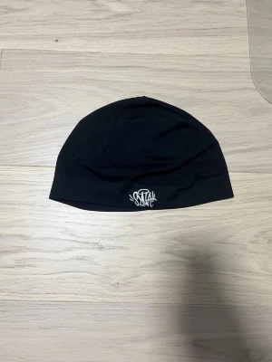 Svart mössa från syna world - En skull cap från syna world, nästan helt ny, tvättas innan leverans