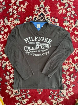 Långärmad Tommy Hilfiger tisha - Långärmad Tommy Hilfiger T-shirt i riktig bra skick. Taggen säger xxl, detta stämmer inte alls utan den är snarare m. Som ni kan se på trycket är tröjan i väldigt bra skick. Kom pm vid frågor. Kan slänga in gratis om du köper ett par jeans.