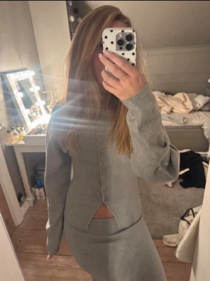 Grått set - Snygg grått set från Gina tricot. Tröjan har långa ärmar och knappar framtill samt en croppad passform med slits framtill och är tillverkad i mjukt material som känns skönt mot huden. Kjolen är i S och har prislappen kvar. Tröjan är utan prislapp och i storlek XS. Settet är endast testat och är i nyskick. Hör av er vid mer frågor💞