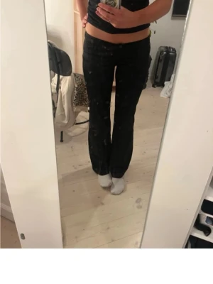 Svarta bootcut byxor - Säljer ett par svarta byxor med bootcut-modell och låg midja. byxorna har knapp och dragkedja framtill samt klassiska fickor.