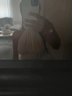 Fin topp med öppen rygg  - Snygg vit halterneck topp med omlottknytning i midjan och nacken. Toppen har volangdetaljer och är tillverkad i ett lätt, luftigt material som ger en flowy känsla. Perfekt för dig som gillar trendiga och feminina plagg.e