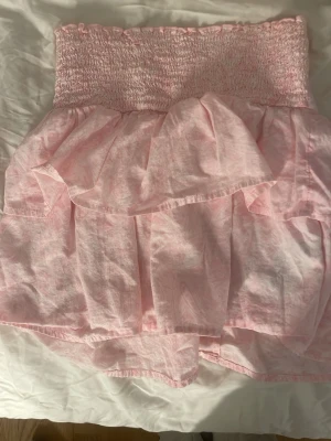 Ljusrosa tubtop med volanger  - Supersöt tubtop i storlek 158/164. Har tyvärr inte banden till den men det funkar bra utan.
