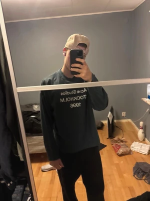 Acne Studios långärmad t-shirt - Mörkblå långärmad t-shirt från Acne Studios med vit text 'Acne Studios STOCKHOLM 1996' på bröstet. Klassisk rund hals och relaxed fit, perfekt för en clean och stilren look. Kommer med originalpåse. Nypris 3200kr, mitt 1499. Denna tröja är som ny då den bara är använd 1 gång.