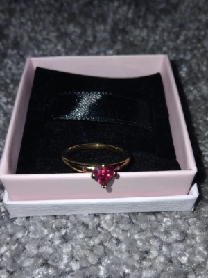 Pandora Ring - Ring från pandora (En Kärleksexplosion). Säljer en 14K guld ring från pandora med hjärtformad sten, eftersom storleken var för stor. Storlek: 48. Diameter: 15.3mm. Nypris: 800kr. Hör av dig vid frågor! Ringen är givetvis äkta💍 