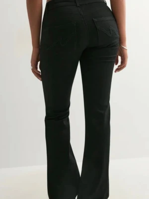 Low Waist Perfect Bootcut Jeans från Nelly  - Snygga svarta bootcut jeans från Wrangler med klassiska fem fickor och diskret broderi på bakfickorna. Jeansen har låg midja och sitter bekvämt och formar sig efter kroppen. De är köpta för 699kr, men eftersom de blivit försmå så säljer jag dem vidare💞