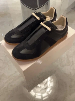 Svarta sneakers från maison margiela med beige sula - Säljer dessa feta maison margiela gats i storlek 43 och pris kan diskuteras!