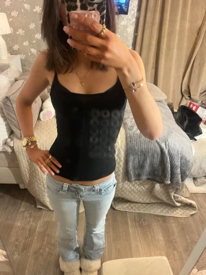 Ljusblå bootcut jeans - Säljer ett par ljusblå bootcut jeans med klassisk femficksdesign och låg midja. Jeansen har en avslappnad passform och är perfekta för en casual look. Inga synliga slitningar eller detaljerade dekorationer. Passar dig som gillar en enkel och stilren stil. Är storlek 34 men passar mer 36, är 171 för referens. Knappficka där bak 