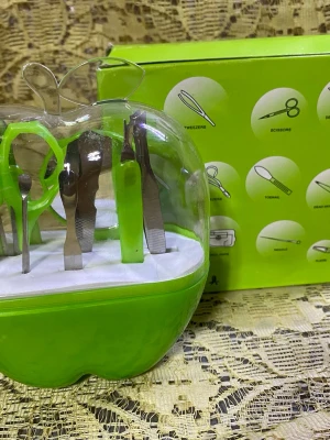 Nagelvårdset i äppelformad ask - Nagelvårdset med flera verktyg i en grön äppelformad plastask med transparent lock. Innehåller bland annat nagelsax, pincett, nagelfil och nagelbandsskärare i metall och plast. Perfekt för att fixa naglarna hemma med stilren förvaring.