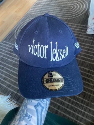Victor Leksell Merch keps - Säljer en ovanlig keps från Victor Leksells merchsläpp 2022, denna är inte lika lätt att få tag i längre. köpt på plats på en av hans konserter. Knappt använd bara något dammig. Alla lappar sitter kvar.