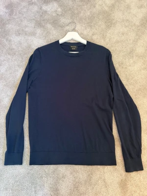 Marinblå merinoull tröja Massimo Dutti - Klassisk marinblå stickad tröja från Massimo Dutti i merinoull. Tröjan har rund halsringning, långa ärmar och ribbade muddar vid ärmslut och nederkant. Perfekt basplagg för lager på lager och stilrena outfits. Använt några gånger men passar ej längre tyvärr.