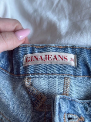 Ljusblå raka jeans från Gina Tricot - Ljusblå jeans från Gina Tricot med rak passform och klassisk femficksdesign. Jeansen har synliga sömmar i kontrastfärg och är tillverkade i denim. Perfekta för en avslappnad och trendig look.
