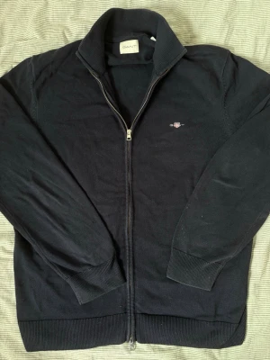 Gant zip knit sweater - Mörkblå stickad tröja från Gant med dubbel dragkedja samt ståkrage i storlek XL men sitter mer som L. Tröjan har ribbade muddar och nederkant. Använder aldrig längre. Tveka inte o skriv för frågor etc 🎶🎶✨