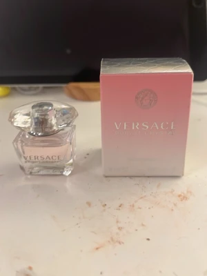 Versace Bright Crystal parfym 5 ml - Versace Bright Crystal parfym i en elegant liten glasflaska med diamantformad kork. Parfymen har en ljusrosa nyans och kommer i en snygg rosa och silverfärgad kartong. Perfekt för dig som gillar lyxiga och fräscha dofter.