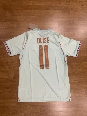 Bortaställ Frankrike VM2026 Olise 11 - Otrolig fin Frankrike bortaställ för VM 2026 med Olise 11 på ryggen. Tröjan är i storlek M och är helt ny!! Bundla o få rabatt.