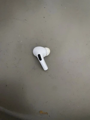 Vit trådlös in-ear hörlur ( AirPods Pro gen 2) - Säljer en vit trådlös in-ear hörlur med silikonpropp och stilren design. Hörluren har en avlång form med svart detalj på sidan och passar perfekt för dig som gillar smidig och modern teknik. Pris kan diskuteras vid snabb affär
