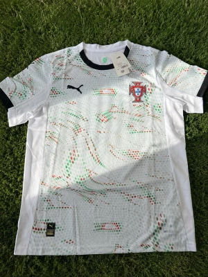 Puma Portugal 2025 bortatröja 🇵🇹 - Officiell Portugal 2025 bortatröja i bra skick. Snygg design och bekväm passform, perfekt för fans eller träning. Inkluderar kvitto som bevis på äkthet. Inga större skador eller problem. Hör gärna av dig om du har frågor eller vill ha fler bilder. Snabb leverans möjligt. ⚽🇵🇹