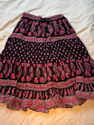 Maxi kjol Boho svart rosa - Snygg maxikjol med rosa och svart mönster. Det går att diskutera pris. Passar xs-m . Om man är 160 passar som maxi och om längre passar som mindi. TikTok & vinted & insta: melioraofficials