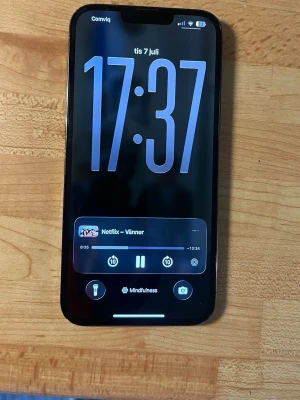 Svart iPhone med stor skärm - Snygg svart iPhone med modern design och stor skärm. Telefonen har tunna kanter och rundade hörn, vilket ger en stilren känsla. Perfekt för streaming, sociala medier och appar. Klassisk Apple-look med glas på framsidan.