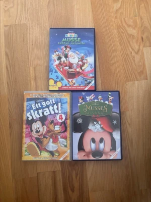 3 st Disney Musse Pigg DVD-filmer - Säljer ett paket med tre Disney DVD-filmer: 'Klubbhus Musse Räddar Jultomten', 'Ett gott skratt!' och 'Musses Jul i Ankeborg'. Omslagen är färgglada med motiv av Musse Pigg och hans vänner. Perfekt för dig som gillar klassiska tecknade filmer och Disney.