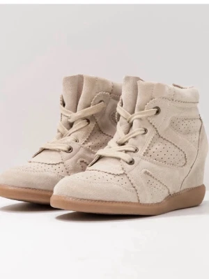 Beiga kilklackade sneakers i mocka - Snygga beige sneakers med kilklack och perforerade detaljer. Skorna är gjorda i mocka med gummisula och har snörning framtill. Perfekta för dig som vill ha en sportig look med lite extra höjd. De är liknande till Isabel Marant-skorna och väldigt fina i bra kvalitet. Har endast använt dem en gång men har nu köpt en annan storlek. Som nya! Storlek 37, priset går att diskutera!