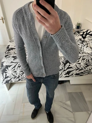 Ljusgrå stickad cardigan med knappar - Snyggt stickad cardigan från Massimo Dutti. Tröjan är grå/blå (jag tycker den är grå men nån sa att den var lite mer blå). 😁                                   ——————————————————————————                                                    📐| Storlek: M                                                          👖| Märke: Massimo Dutti                                     🔎| Skick: Fint skick                                               ✍🏻| Skriv om du har några frågor