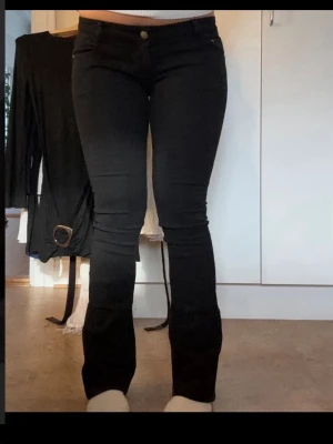 Svarta bootcut jeans - Säljer ett par svarta bootcut jeans. Jeansen har en snygg passform som sitter tight över låren och släpper ut vid vaden. Midjemått 37 cm, Innerbenslängd 79 cm