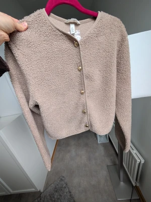 Kofta  - Mysig kofta med guld knappar . Ny med lapp kvar 