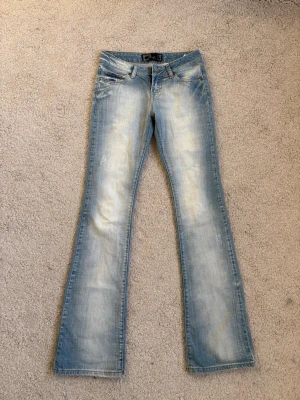Ljusblå bootcut jeans från Blue Cult - Säljer ett par ljusblå bootcut jeans från Blue Cult med slitna detaljer och låg midja. Skriv vid frågor 💗