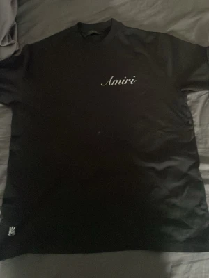 Svart Amiri t-shirt med logga - Snygg svart t-shirt från Amiri med vit logga tryckt på bröstet och i större format på ryggen. Köpt från Minto för 2400kr har används en gång. 