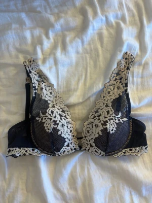 Intimissimi Balconette BH Elena Pretty Flowers (blu intenso / vaniglia) - Elegant balconette-bh från Intimissimi i modellen Elena med vackert blommönster i marinblå (blu intenso). Ger ett naturligt lyft och en fin, rundad form 🌙 Perfekt under urringade toppar eller klänningar.  • Modell: Elena Balconette • Färg: Marinblå / Blu intenso / vaniglia med blommor • Skick: Mycket bra • Storlek: 70B   Stilren och feminin – ett riktigt fint plagg i garderoben.   Elegant balconette bra from Intimissimi, model Elena, in a beautiful deep blue (blu intenso) floral design. 