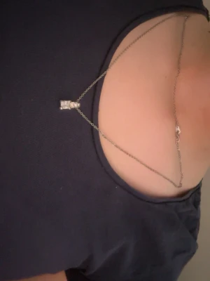 Silverhalsband med rektangulär sten - Otroligt snygg halsband i silverfärgad metall med en tunn kedja och ett hängsmycke i form av en rektangulär klar sten. Anledningen till att jag säljer är pga att jag använder mig av guld, inte silver 😞Vill inte sälja för den är så vacker men tyvärr behövs göras då den har aldrig kommit till användning. Tyvärr kommer jag inte ihåg vart jag köpte den från.