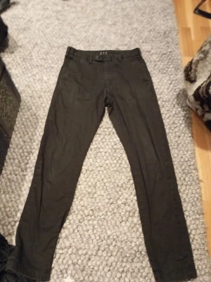 Svarta chinos ASKET - Säljer ett par svarta chinos med klassisk rak passform och bälteshällor. Byxorna har diskreta fickor både fram och bak och är tillverkade i ett mjukt bomullsmaterial. Perfekta för dig som gillar en stilren och enkel look. Nypris är 1800. W 28 L 30.