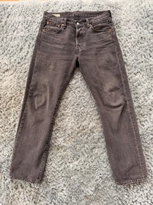 Svarta raka jeans från Levi's - Säljer ett par svarta raka 501 Levis jeans. Lite lätt men snygg tvätt. Storleken är W30 L30 men sitter mer som W31-32. Hör av dig vid frågor och funderingar. Mhv