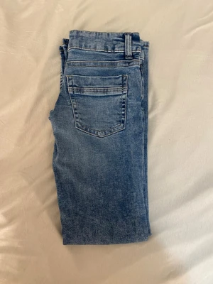 Blå bootcut jeans - Säljer ett par klassiska blå bootcut jeans från Gina. Jeansen har bälteshällor och snygga sömmar baktill. Perfekta till vardags och passar till det mesta. Materialet är mjukt denim i bomull.
