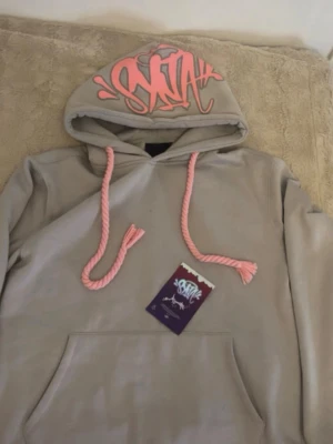Syna world hoddie - grå hoodie av syna world/ använd 3 gånger ugf. tjocka rosa snören💗