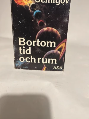 Bortom tid och rum pocketbok - Science fiction-bok med titeln 'Bortom tid och rum' av Eugen Semitjov. Omslaget har ett färgstarkt rymdmotiv med planeter och stjärnor mot svart bakgrund. Pocketformat med mjuka pärmar, perfekt för dig som gillar rymdäventyr och framtidsvisioner.