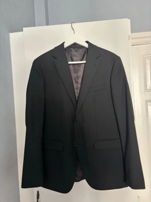 Kostym kit  - Säljer ett Riley kostym kit med svart kavaj storlek 48, vit skjorta storlek S och svarta kostymbyxor storlek 48. Använts 1-2 gånger, skriv för fler bilder och diskutera pris. Hela kitet säljs för 650 kr