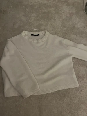 Vit stickad tröja från 157  - PRIS KAN DISKUTERAS, En enkel och fräsch vit stickad tröja från 157 i storlek XS. Tröjan har rund hals, ribbade muddar och är långärmad. Perfekt för lager-på-lager och chill dagar. Materialet är mjukt och känns skönt mot huden. Har blivit väldigt kort i både ärmar allmänt