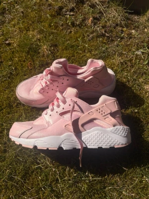 Nike Air Huarache rosa sneakers - Säljer ett par Nike Air Huarache sneakers i ljusrosa med vita detaljer använda 1 gång så perfekt skick! Snöret på ena skon har virat upp sig men går lätt att fixa, storlek 39 men passar en 37-38 (ni som haft dessa sedan innan vet att storlekarna på denna modellen är märklig) 